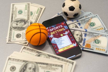 Foto de Smartphone con aplicación móvil de juegos de azar y pelota de baloncesto con el dinero de cerca. Concepto de deporte y apuestas. Foto de alta calidad - Imagen libre de derechos