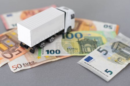 Téléchargez les photos : Camion jouet blanc sur les billets en euros. concept pour la logistique, le transport et la finance. Photo de haute qualité - en image libre de droit