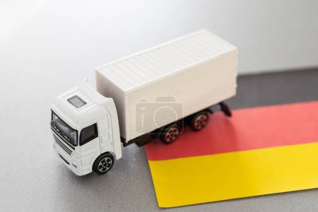 Mini juguete en la mesa con fondo borroso. Concepto de envío industrial. Camión de juguete, bandera de Alemania. Foto de alta calidad