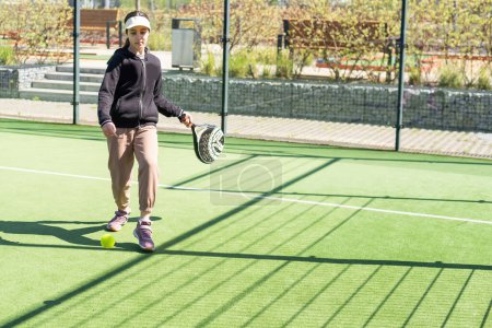  niña jugando padel y golpeando la pelota con su raqueta al aire libre conceptos deportivos. Foto de alta calidad