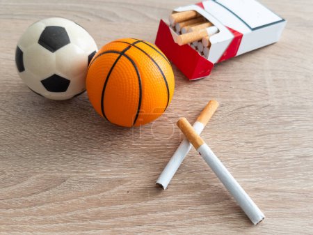 Photo for Smoking or sports. Sport ball and pack of cigarettes on table background. Top view. High quality photo - Royalty Free Image