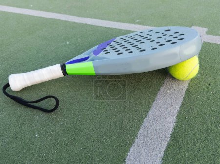 Background of padel racket and ball on artificial grass floor in outdoor court. Top view. High quality photo
