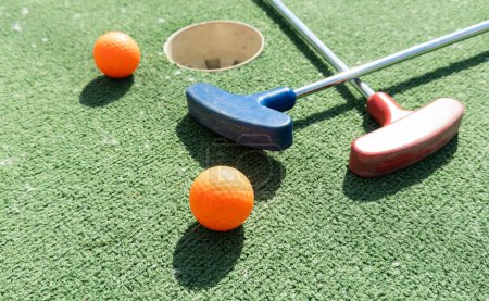Bunte Golf Putter mit Golfbällen auf Kunstrasen. Hochwertiges Foto