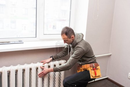 Central heating mechanic and handyman fixing home radiator, gas crisis and seasonal issues. High quality photo