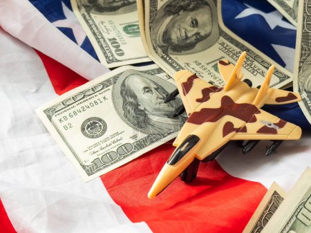 Background of one hundred dollar bills with model fighter airplane . High quality photo