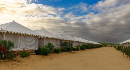 Téléchargez les photos : Tente camping hôtel pour touristes dans le désert de thar sous le ciel Moody à Jaisalmer, Rajasthan. - en image libre de droit