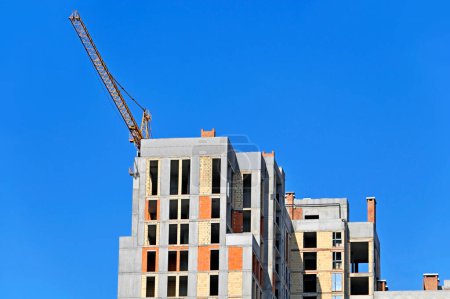 Photo for Highrise construction site with crane and blue sky - Royalty Free Image