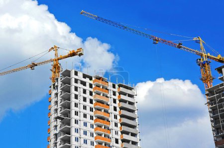 Multistory construction site with crane and blue sky