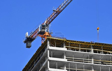 Photo for Crane and highrise building construction against blue sky - Royalty Free Image