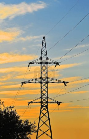 High voltage transmission line over sunset sky background