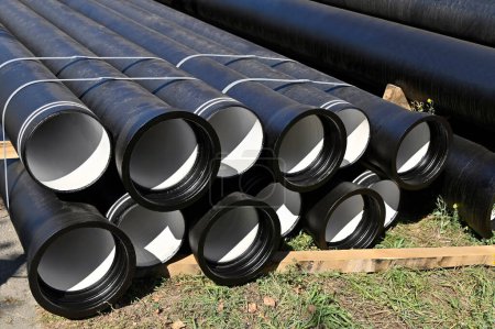 Photo for Reinforced concrete sewer pipes, stacked on construction site - Royalty Free Image