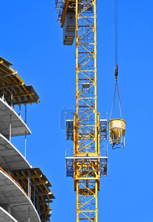 Photo for Crane lifting cone tank for concrete on construction site - Royalty Free Image