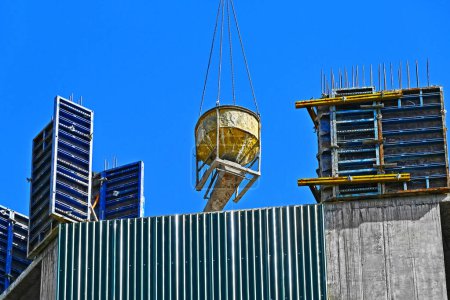 Photo for Crane lifting cone tank for concrete on construction site - Royalty Free Image