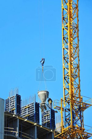 Photo for Crane lifting cone tank for cement on construction site - Royalty Free Image