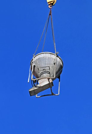 Crane lifting cone tank for cement on construction site