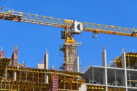 Photo for Crane and high-rise building construction against blue sky - Royalty Free Image