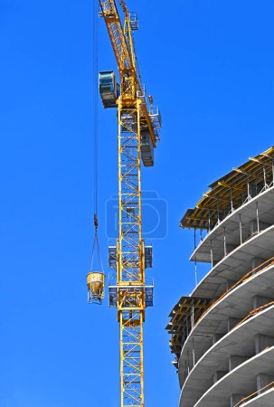Photo for Crane lifting cone tank for cement on construction site - Royalty Free Image