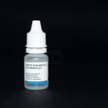 eye drops in a small transparent bottle on a black background