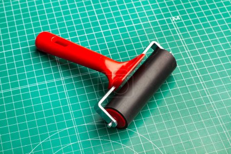 Photo for Rubber roller for engraving on a green cutting matt - Royalty Free Image
