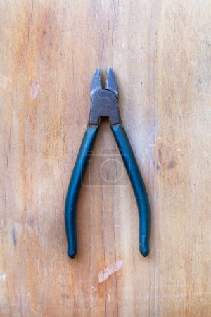 Pliers on a wooden background in a top view