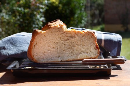 Center of a loaf of bread on a wooden table on a sunny day