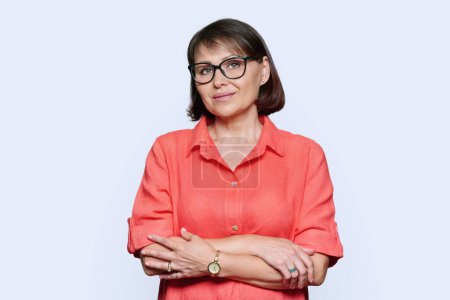 Photo for Portrait of beautiful mature woman in glasses in red dress looking at camera on white studio background. Successful attractive female 45 years old, beauty health happiness, fashion, middle age concept - Royalty Free Image