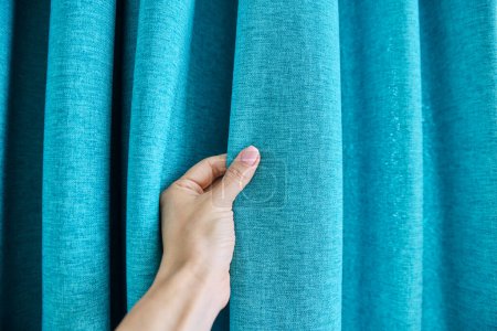 Photo for Blue turquoise textured polyester curtains on window, close-up of hand touching curtains. Textile window decoration, fashion, style, design concept - Royalty Free Image