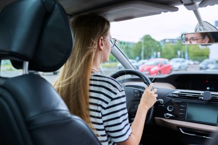 Photo for Teenage girl driver in glasses sitting behind wheel of car, carefully serious attentive looking at road, young female received license to drive car. Youth, auto school, lifestyle concept - Royalty Free Image