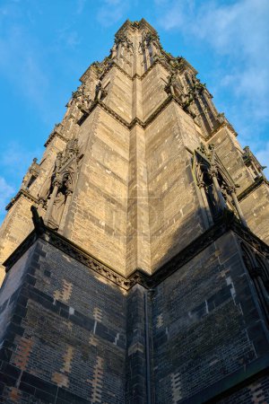 Photo for Black burnt spire of the Gothic Revival church of St. Nicholas Cathedral in Hamburg against the background of the dark sky - Royalty Free Image
