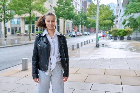 Photo for Portrait of smiling teenage girl looking at camera on street of modern city, copy space road. Adolescence, urban lifestyle, young people concept - Royalty Free Image