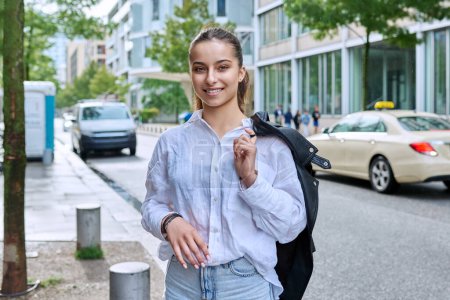 Photo for Portrait of smiling teenage girl looking at camera on street of modern city. Adolescence, urban lifestyle, young people concept - Royalty Free Image