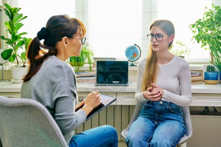 Photo for Young teenage girl high school student talking with psychologist, therapist, counsellor, social worker. Mental session therapy, support, psychology, psychotherapy, adolescence, youth concept - Royalty Free Image