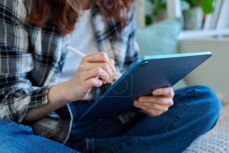 Photo for Close-up of a female hand with a stylus holding a drawing on a digital tablet. Technologies, leisure, creativity, education, freelance work, youth concept - Royalty Free Image