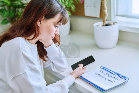 Photo for Girl user typing password on smartphone, on web verification page. Password written in notepad, email electronic banking applications, security authorization system, privacy confidentiality technology - Royalty Free Image