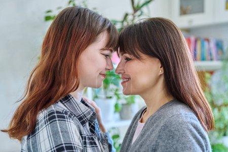 Photo for Close-up profile portrait of mother and daughter 18-20 years old. Family, communication, motherhood, friendship, relationship between parent and teenage daughter, mothers Day concept - Royalty Free Image