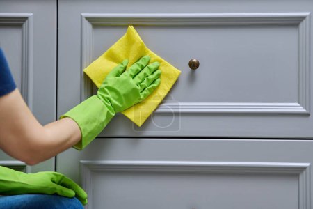 Photo for Close-up hands in protective gloves cleaning, wiping dust from furniture with soft cloth, polishing the wooden surfaces of furniture. Housekeeping, housework, housecleaning, cleaning service concept - Royalty Free Image