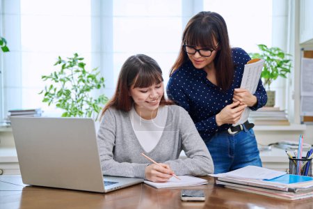 Foto de Estudiante adolescente que estudia en el escritorio con la computadora, profesor mentor entrenador ayudando a la enseñanza. Educación, enseñanza, concepto de juventud - Imagen libre de derechos