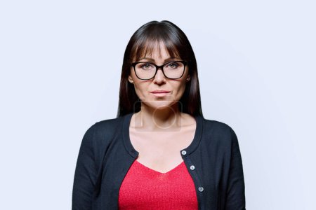 Photo for Portrait of serious middle aged woman on white background. Confident female with glasses looking at camera. 40s professional, beauty health lifestyle work business services - Royalty Free Image
