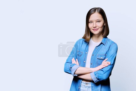 Photo for Young confident woman with crossed arms on white studio background copy space for you text image. Smiling attractive 20s female in denim looking at camera. Lifestyle fashion beauty style youth concept - Royalty Free Image