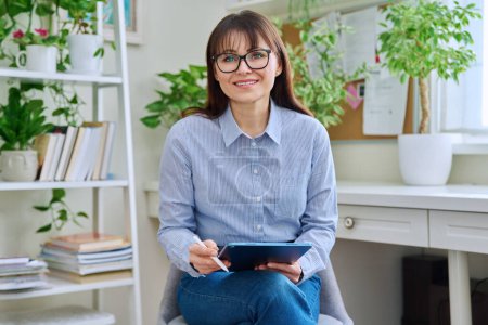 Photo for Portrait of woman mental professional psychologist therapist social worker counselor sitting in office with digital tablet positive looking at camera. Psychology psychotherapy therapy help support - Royalty Free Image