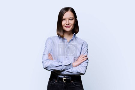 Photo for Young confident smiling business woman with crossed arms on white studio background. Positive happy female in shirt, student worker owner entrepreneur looking at camera. Business work education people - Royalty Free Image
