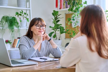 Photo for Middle-aged female psychologist, psychotherapist, counselor, social worker working with young woman patient. Psychology therapy professional help consultation treatment support mental health concept - Royalty Free Image