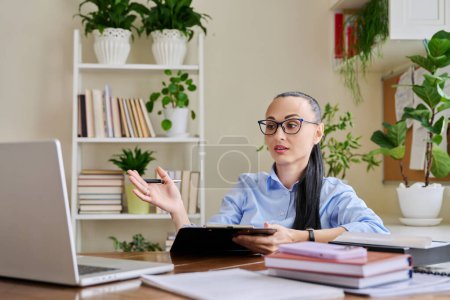 Téléchargez les photos : Femme psychologue thérapeute mentale conseiller travailleur social travaillant à distance à l'aide d'un ordinateur pour une réunion de thérapie en ligne. Femme avec presse-papiers regard parler à l'ordinateur portable. Technologie psychologie psychothérapie - en image libre de droit