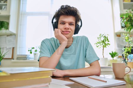 Photo for Webcam view of college student guy wearing headphones, talking looking at camera, sitting at desk in home. Young male studying online, video chat call conference, e-learning technology education - Royalty Free Image
