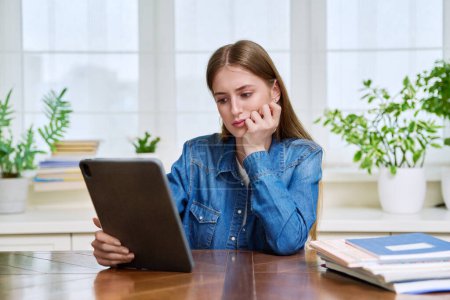 Photo for Young teenage female student sitting at home looking talking in web camera of digital tablet. Girl teenager 16,17,18 years old studying remotely, video conference call, e-learning technology education - Royalty Free Image