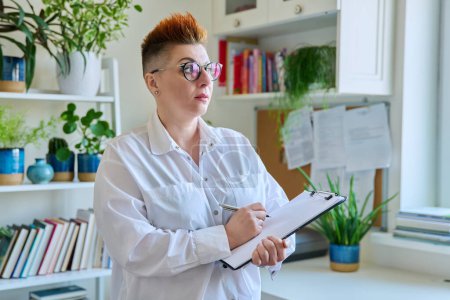 Photo for Portrait of serious female psychotherapist with clipboard at workplace in office. Professional mental therapist counselor psychologist social worker behavior. Health care services, treatment - Royalty Free Image