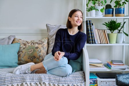 Photo for Portrait of young attractive smiling woman in home interior. Happy cheerful relaxed 20s female looking away, sitting on couch. Beauty, youth, happiness, health, lifestyle concept - Royalty Free Image