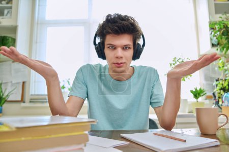 Photo for Webcam view of college student guy wearing headphones, talking looking at camera, sitting at desk in home. Young male studying online, video chat call conference, e-learning technology education - Royalty Free Image