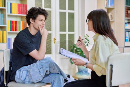Female psychologist working with young male college student in office educational building. Mental health of youth, social service, psychology, psychotherapy, behavior, support treatment counselling