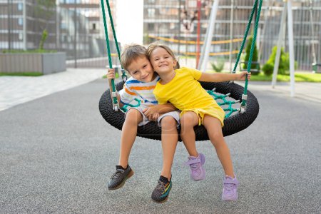 A boy and a girl ride on a swing, a spider web, a nest and have fun